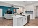 Modern kitchen with white cabinets, stainless steel appliances, and an open view to the living room at 295 Barbour Farm Ln, Four Oaks, NC 27524