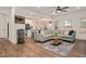 Open-concept living room with a large sectional sofa, hardwood floors, and seamless flow into the kitchen at 295 Barbour Farm Ln, Four Oaks, NC 27524