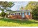 Charming brick home with blue shutters, complemented by a well-maintained front yard and lush greenery at 300 Grove St, Oxford, NC 27565