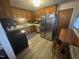The kitchen has wood cabinets, stainless steel refrigerator, laminate counters and floors, and eat-in nook at 300 Grove St, Oxford, NC 27565