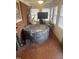 Sunroom featuring an inflatable hot tub, brick accent wall, tile floors, and plenty of natural light at 300 Grove St, Oxford, NC 27565
