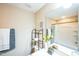 Neutral bathroom with white shower curtain, dark metal shelving, and decorative artwork at 3005 Domaine Dr, Wake Forest, NC 27587