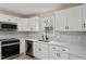 Bright kitchen featuring stainless steel appliances, white cabinets, and light gray backsplash at 312 W Union St, Hillsborough, NC 27278
