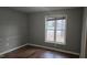 Cozy bedroom features hardwood floors and natural light from a large window at 3916 Allen W St, Raleigh, NC 27603