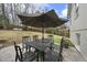 Outdoor dining area with a large table, seating for six, and shaded by a large umbrella at 400 Edinburgh Dr, Cary, NC 27511