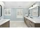 Bright bathroom featuring double sinks, shuttered windows and a soft, calming color scheme at 400 Edinburgh Dr, Cary, NC 27511