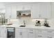 Modern kitchen with custom white cabinetry, stainless steel appliances, and a built-in wine refrigerator at 400 Edinburgh Dr, Cary, NC 27511