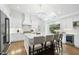 Bright kitchen features an island, seating, stainless steel appliances, white cabinets, & herringbone backsplash at 400 Edinburgh Dr, Cary, NC 27511