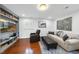 Comfortable living room with hardwood floors, recliner, grey sofa and ottoman, and built in shelves at 400 Edinburgh Dr, Cary, NC 27511