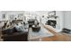 Open-concept living room with hardwood floors, a brick fireplace, and views into the modern white kitchen at 400 Edinburgh Dr, Cary, NC 27511