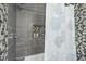 Shower with large grey tiles, a mosaic accent and niche, and modern shower hardware at 400 Edinburgh Dr, Cary, NC 27511