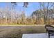 Large backyard with mature trees and a chair on the patio, creating a serene outdoor space at 449 Willard Woods Dr, Wendell, NC 27591