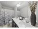 Modern bathroom with double sinks, a decorative vase, and a patterned shower curtain at 449 Willard Woods Dr, Wendell, NC 27591