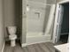 Bathroom with luxury vinyl flooring, and a shower and tub combo with tiled wall at 4807 Tyne Drive, Durham, NC 27703