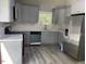 Updated kitchen features stainless appliances, gray cabinets, and luxury vinyl flooring at 4807 Tyne Drive, Durham, NC 27703