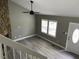 Bright living room features luxury vinyl flooring, stone fireplace, and ceiling fan at 4807 Tyne Drive, Durham, NC 27703