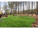 Manicured lawn with wooded backdrop offers a private outdoor retreat, complete with a modern hot tub at 49 Bonterra Way, Chapel Hill, NC 27516