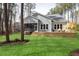 Expansive backyard features lush green lawn, a spacious deck, screened in porch, and landscaped features at 49 Bonterra Way, Chapel Hill, NC 27516