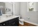 Bathroom featuring a black vanity, white sink, and toilet, complemented by stylish wall art at 49 Bonterra Way, Chapel Hill, NC 27516