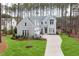 A charming, two-story grey home features a manicured lawn and a long driveway at 49 Bonterra Way, Chapel Hill, NC 27516