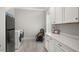Laundry room with white cabinets, a quartz countertop, a black rocking chair, and stainless steel appliances at 49 Bonterra Way, Chapel Hill, NC 27516