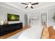 Large main bedroom featuring hardwood floors, tray ceiling, large windows, and open doorway at 49 Bonterra Way, Chapel Hill, NC 27516