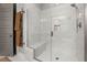 The shower has a frameless glass door and marble tiled walls with a built in seat at 49 Bonterra Way, Chapel Hill, NC 27516