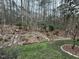 Well-maintained backyard featuring mature trees, small bushes, and natural stone walkways at 4909 Willow Tree Ln, Clayton, NC 27520