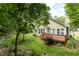 The exterior shows a lush backyard with a deck, well-manicured lawn, and mature trees at 4909 Willow Tree Ln, Clayton, NC 27520