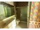 A full bathroom with a shower, toilet, sink, and vintage wallpaper at 4909 Willow Tree Ln, Clayton, NC 27520