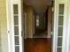Inviting foyer with hardwood floors and french doors, leading to carpeted hallways at 4909 Willow Tree Ln, Clayton, NC 27520