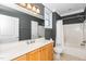 Bathroom features a combination shower and tub, wood cabinets, and white quartz countertop at 501 Finsbury St # 100, Durham, NC 27703