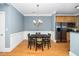 An open dining room features wood floors, chandelier lighting, and stainless steel appliances at 501 Finsbury St # 100, Durham, NC 27703