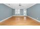 Bright living room featuring hardwood floors, fan, natural light, and neutral gray walls at 501 Finsbury St # 100, Durham, NC 27703