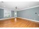 Bright living room with hardwood floors, fan, natural light, and neutral gray walls at 501 Finsbury St # 100, Durham, NC 27703