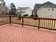 View of the back deck with wood planks and railings overlooking the backyard and neighboring houses at 501 Liberty Rose Dr, Morrisville, NC 27560