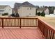 View of the back deck with wood planks and railings overlooking the spacious backyard and neighboring houses at 501 Liberty Rose Dr, Morrisville, NC 27560