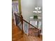 Stairway with hardwood steps, dark ornate metal railings, and a decorative light fixture at 501 Liberty Rose Dr, Morrisville, NC 27560