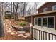 Backyard exterior featuring a wood deck and a stone pathway through mulched gardens at 524 Farmington Woods Dr, Cary, NC 27511