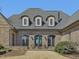 Rear exterior featuring covered patio, manicured lawn, and arched windows at 601 Golfers Vw, Pittsboro, NC 27312