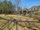 A well-maintained backyard with a black iron fence, landscaping, and a view of the house at 601 Golfers Vw, Pittsboro, NC 27312