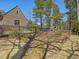 The backyard features a wrought iron fence, mature trees, and established landscaping at 601 Golfers Vw, Pittsboro, NC 27312