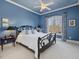 Primary bedroom with a decorative tray ceiling, a large window and blue walls at 601 Golfers Vw, Pittsboro, NC 27312