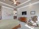 Spacious bedroom featuring a ceiling fan, TV, and inviting sitting area at 601 Golfers Vw, Pittsboro, NC 27312