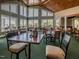 Well-lit dining room with high windows, featuring tables and chairs, accented by wood trim and a green carpet at 601 Golfers Vw, Pittsboro, NC 27312