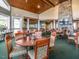 Elegant dining room with wood tables, upholstered chairs, and a stone fireplace under a high wood-paneled ceiling at 601 Golfers Vw, Pittsboro, NC 27312