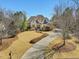 Stately stone home with a long driveway and well-manicured landscaping at 601 Golfers Vw, Pittsboro, NC 27312