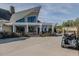 Beautiful clubhouse exterior features a patio with outdoor seating, landscaped gardens, and a nearby golf cart at 601 Golfers Vw, Pittsboro, NC 27312