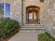 Charming stone facade with wood double doors and manicured landscaping at 601 Golfers Vw, Pittsboro, NC 27312