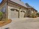 Two car attached garage with stone facade and brick accents at 601 Golfers Vw, Pittsboro, NC 27312